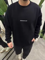 Buzo negro de algodón con corte amplio y bordado blanco con la leyenda "BOHEMIANDESIGN®" en el frente.