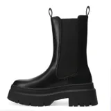 Bota tipo chelsea negra con elásticos laterales y suela gruesa, diseño robusto y moderno.