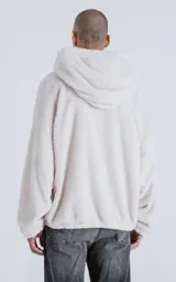 Hoodie blanco de piel de corderito sintético, corte oversize, con capucha ajustable con cordón y bolsillo canguro.