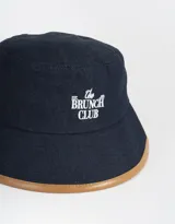 Piluso de denim azul con borde marrón y bordado frontal con la frase "The Brunch Club".