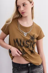 Remera color camel de mangas cortas confeccionada en jersey de algodón, de calce al cuerpo y escote redondo en punto rib a tono. Cuenta con una estampa central al agua de efecto desgastado con la palabra "Music" y estrellas, y un aplique de cadenas y piedras que simula ser un collar.