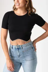 Remera negra de viscosa con mangas cortas, corte crop y detalle de flecos de strass en el ruedo.