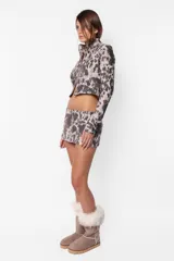 Minifalda de sarga gamuzada con estampado animal print, cierre frontal metálico y recortes horizontales con cierres laterales.