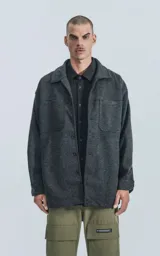 Chaqueta gris de paño con cuello clásico, cierre frontal con botones, bolsillos laterales y corte recto.