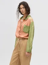 Mono largo de jean celeste con corte holgado, cintura elastizada con cordón ajustable, sin mangas, cuello camisero y cierre frontal con botones. Presenta bordados de motivos playeros en el pecho.