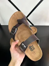 Sandalias de dedo marrones con tiras de ecocuero y hebillas metálicas.
