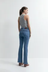 Pantalón de jean de tiro alto, corte ajustado y botamanga acampanada con tajos laterales.