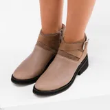 Bota corta de cuero color marrón con cierre lateral, suela de goma negra y hebilla decorativa.