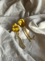Aros colgantes dorados con forma irregular y tiras de strass.