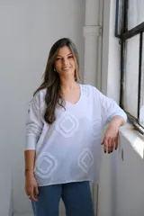 Remera blanca de algodón con cuello en V y mangas 3/4. Presenta apliques de rombos blancos en relieve.