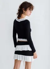 Minifalda negra con volados blancos diagonales.