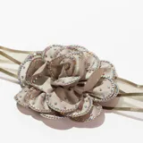 Gargantilla de cinta de organza color dorado con flor de tela color beige cubierta de strass.