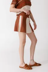 Minifalda marrón con paneles laterales color crema y rayas rojas y marrones.