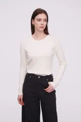 Sweater color crudo, de ajuste al cuerpo y manga larga con cuello redondo.