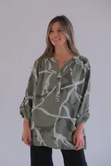 Camisa verde oliva con estampado batik en blanco, cuello mao con botones y mangas largas con trabilla para enrollar.