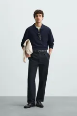 Polo de manga larga color negro, tejido en hilatura con mezcla de algodón y seda, de corte regular fit, con cuello solapa y cierre frontal de botonadura.