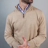 Buzo de punto color azul marino, con cuello alto y medio cierre frontal.