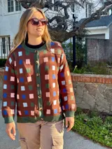 Cárdigan marrón con estampado de cuadros de colores, cuello redondo y cierre frontal con botones.