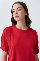 Remera roja de algodón con cuello redondo y mangas cortas con detalle de broderie. Corte clásico.