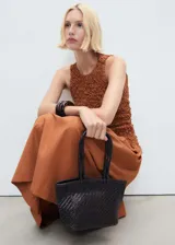 Vestido midi color marrón con textura arrugada en la parte superior y falda acampanada lisa. Sin mangas, con cuello redondo y espalda cerrada.