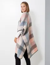 Ruana de tejido soft, color rosa pálido, celeste, gris y beige, con diseño a cuadros. Presenta terminación en zig zag con lana en los bordes y sisa amplia.