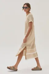 Vestido midi de tejido de punto color beige, con escote redondo, mangas cortas, tajos laterales y diseño con patrón de puntos calados y rayas.