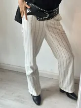 Pantalón sastrero a rayas verticales blancas y celestes.