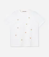 Remera blanca de algodón con cuello redondo y mangas cortas. Presenta pequeños corazones bordados con lentejuelas en el frente.