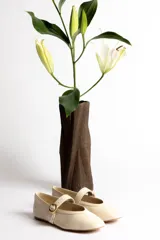 Ballerinas negras de cuero con tira sobre el empeine y hebilla dorada.