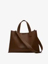 Bolso tote grande color marrón, con doble asa de mano y correa larga extraíble. Interior a contraste con dos compartimentos y bolsillo central con cierre.