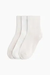 Pack de tres pares de medias blancas de caña media con textura acanalada y borde superior elástico.
