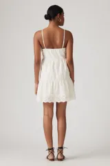 Vestido corto blanco con bordado inglés, breteles finos y falda escalonada.