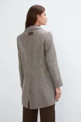 Tapado corto entallado color marrón claro con textura de espiga, cuello solapa y manga larga. Cierre frontal con botones.