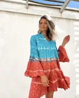 Vestido camisero corto con estampado batik en tonos turquesa y terracota con detalles dorados, cuello mao y mangas 3/4 acampanadas.