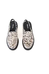 Zuecos destalonados con estampado animal print en tonos marrones y blancos, con detalle de antifaz y suela plana color negro.