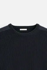 Sweater negro de punto con cuello redondo y manga larga. Presenta parches combinados a tono en hombros y codos.