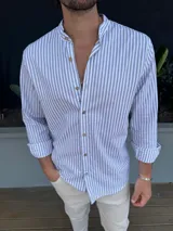 Camisa de manga larga con cuello mao y rayas verticales grises y blancas.