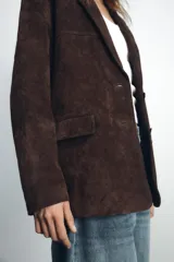 Blazer marrón de piel de ante, con cuello solapa, manga larga, bolsillos con solapa en el delantero y forro interior combinado.