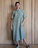 Vestido túnica celeste de lino con rayas verticales blancas, corte recto, cuello camisero y mangas cortas.