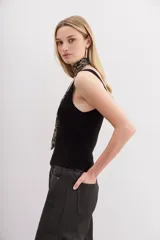 Musculosa blanca tejida en hilado de algodón, con escote en V pronunciado y calce al cuerpo.