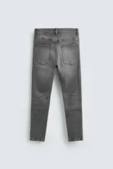 Pantalón de jean color beige, corte skinny, tiro medio, largo cropped y cinco bolsillos.