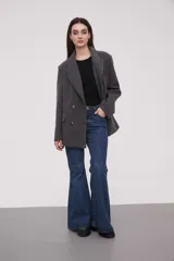 Tapado negro tipo blazer con doble botonadura y solapas, de corte holgado y manga larga.