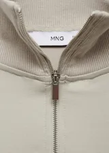 Sweater beige de cuello alto con cierre de cremallera, diseño oversize y mangas largas.
