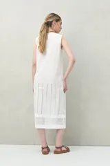 Vestido largo color beige, sin mangas, confeccionado en algodón con calados verticales y bordado tipo ojo de perdiz.