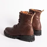 Borcego acordonado de cuero color marrón con suela track negra.