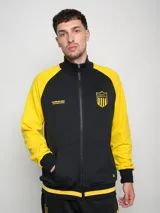 Campera deportiva de felpa negra con mangas amarillas en contraste y escudo del Club Atlético Peñarol estampado en el pecho.