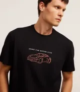 Remera negra de algodón con estampa de un auto deportivo y texto en color naranja.