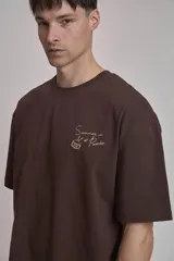 Remera verde oscuro de corte oversize con estampado pequeño en el frente.