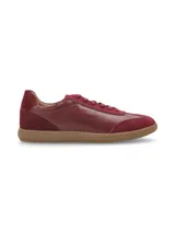 Zapatillas acordonadas doradas de cuero, con suela marrón de goma.