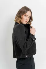 Chaqueta negra tipo biker de gamuza sintética con cuello solapa y manga larga con trabillas en los hombros. Tiene bolsillos delanteros con cremallera metálica y cierre frontal con cremallera.